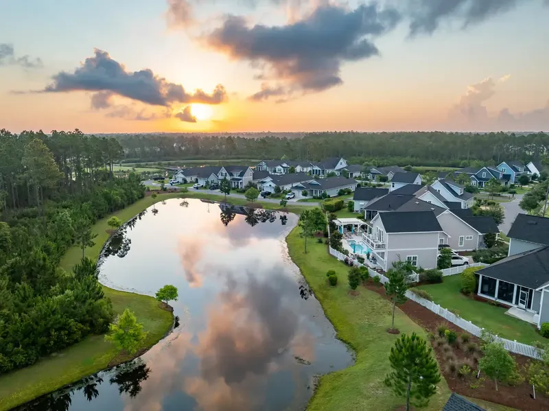 Sunset over a community lake framed by coastal homes